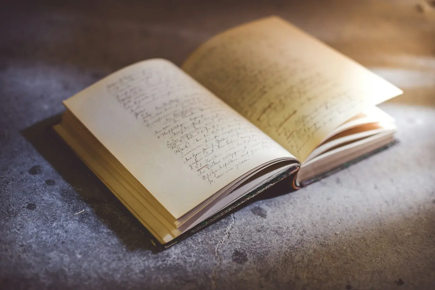 An old notebook lying open, its pages filled with handwriting