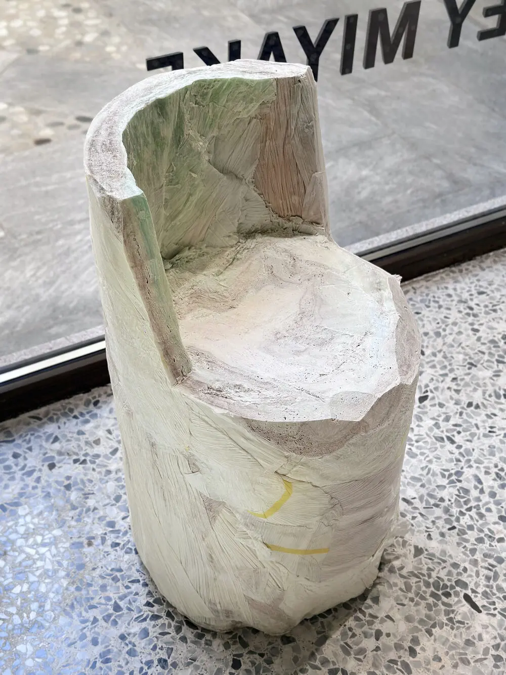 A seat carved from a compressed paper log