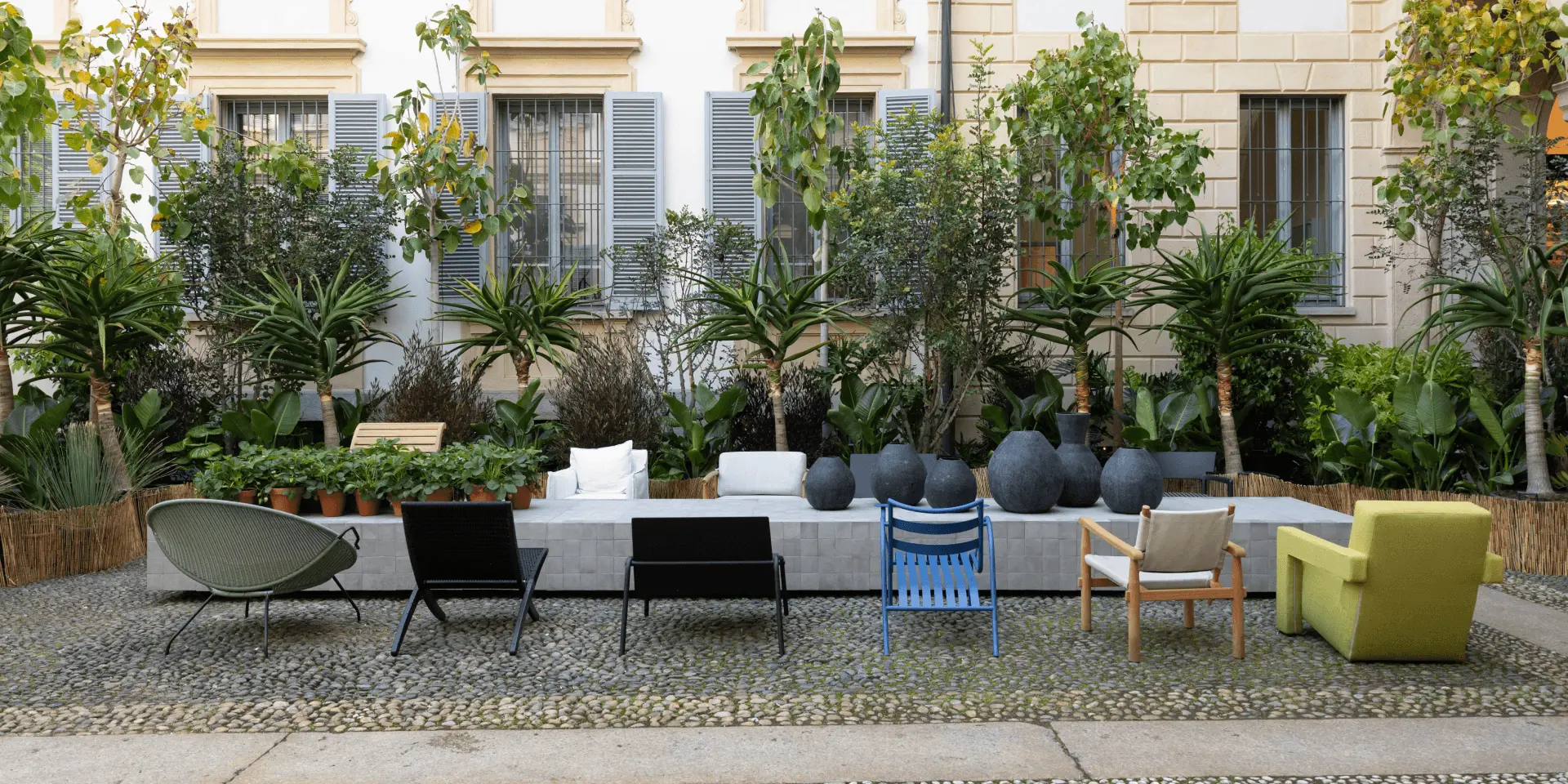 A courtyard garden with outdoor furniture in front of Palazzo Castiglioni, Milan